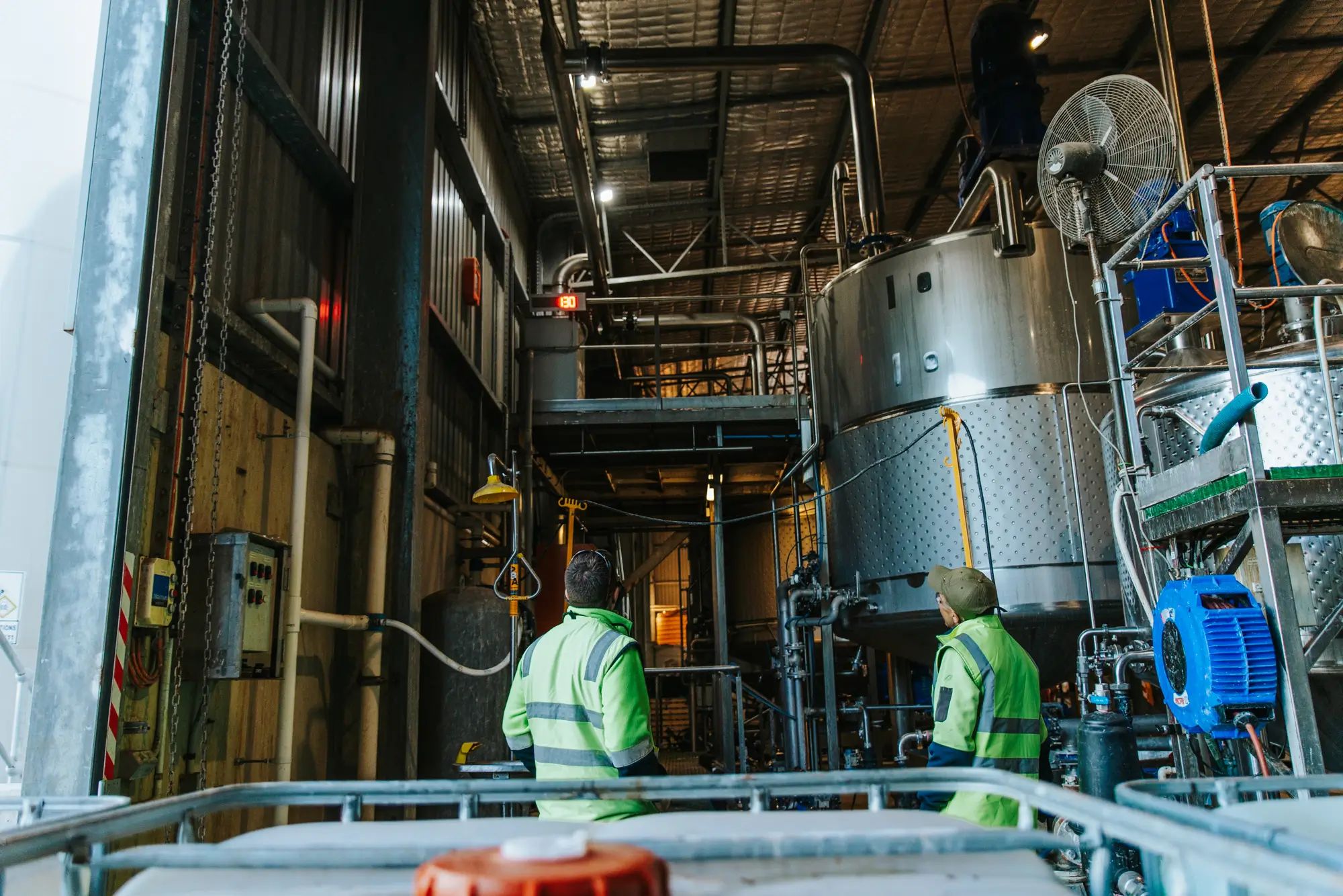 Industrial equipment inside a factory with workers inspecting, highlighting liquid fertiliser and agronomy by NuEdge.